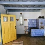 Vidiecka kuchyňa so žltými dverami a modrou pecou