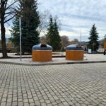 Dva odpadkové koše v parku s dlaždeným chodníkom